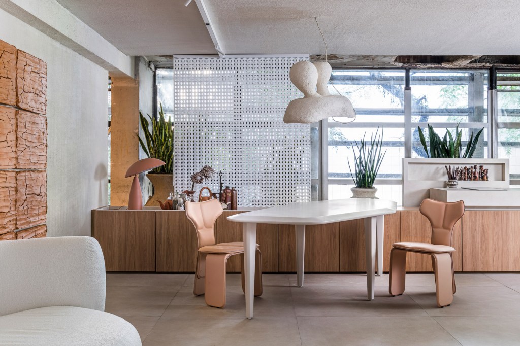 Gustavo Martins Arquitetos - Odoiá. Projeto da CASACOR São Paulo 2023. Na foto, sala de jantar com mesa geométrica, quadro de lama e aparador.