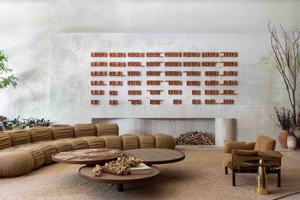 Suite Arquitetos - Casa Kraftizen Cosentino. Projeto da CASACOR São Paulo 2023. Na foto, sala com lareira, sofá curvo e tapete.