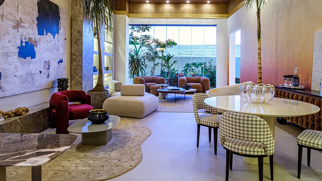 Taynara Wazilewski - Loft Terra Rossa. Projeto da CASACOR Bolívia 2023. Na foto, sala de estar e jantar com cadeiras xadrez, vista para o jardim e quadro.