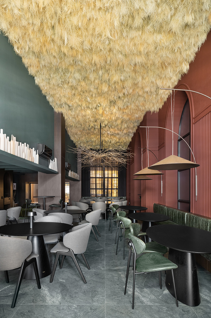 Altera Arquitetura - Ninho & Aspargos. Projeto da CASACOR São Paulo 2023. Na foto, restaurante com aspargos secos no teto e paredes vermelhas e verdes.