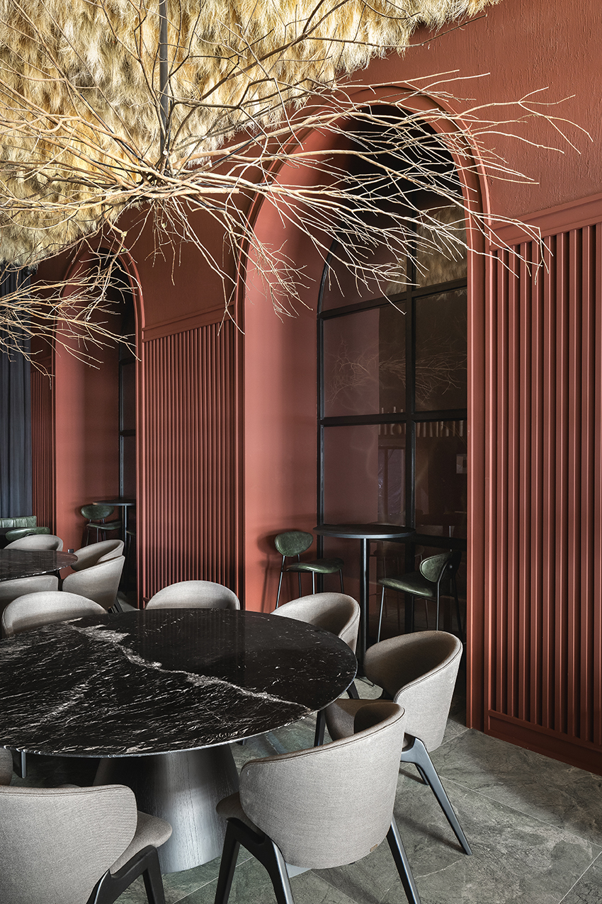 Altera Arquitetura - Ninho & Aspargos. Projeto da CASACOR São Paulo 2023. Na foto, restaurante com parede vermelha e aspargos secos no teto.