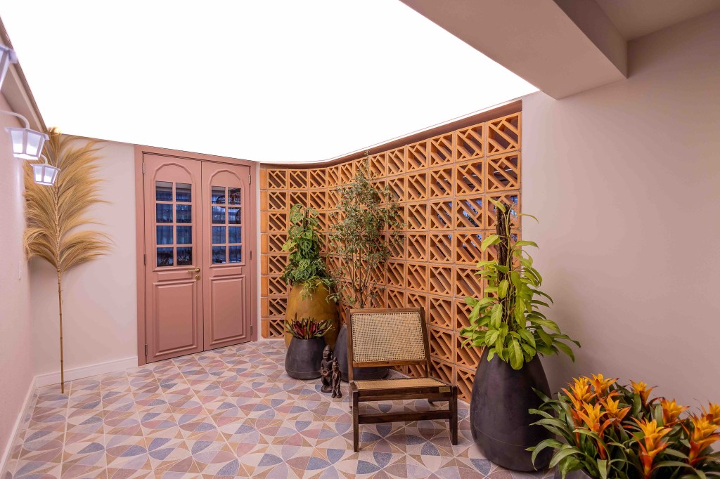 ARQTAB | Maycon Fogliene - A Casa do Ser. Projeto da CASACOR São Paulo 2023. Na foto, entrada da casa com porta rosa e parede de cobogós.
