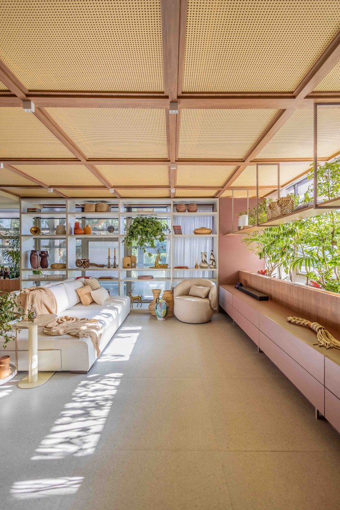 ARQTAB | Maycon Fogliene - A Casa do Ser. Projeto da CASACOR São Paulo 2023. Na foto, sala integrada com sofá, estante, tv e poltrona.