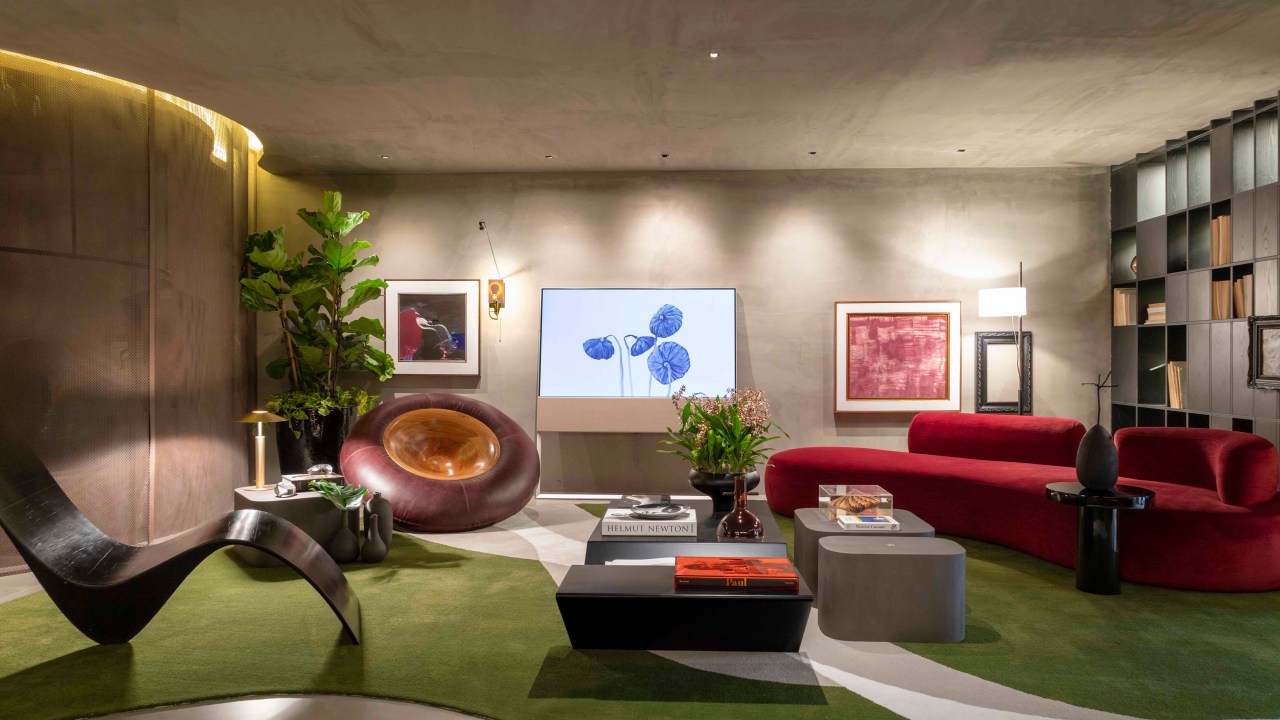 Léo Shehtman - Memórias. Projeto da CASACOR São Paulo 2023. Na foto, sala com sofá vermelho, estante, poltronas e tapete