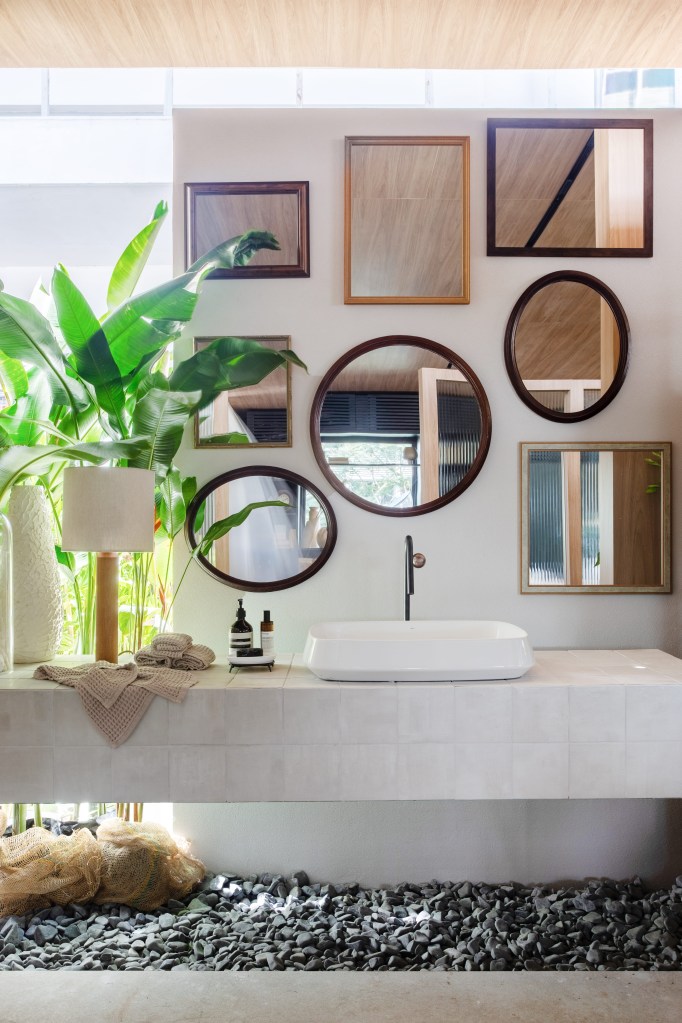 Navarro Arquitetura - Casa Araxá. Projeto da CASACOR São Paulo 2023. Na foto, banheiro com seixos no piso e composição de espelhos.