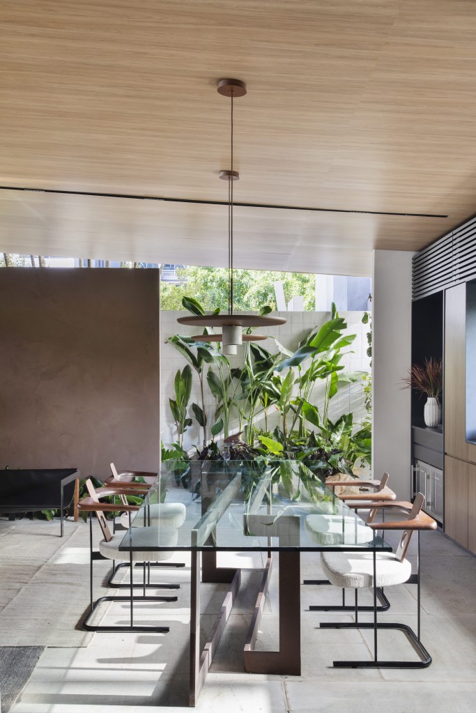 Navarro Arquitetura - Casa Araxá. Projeto da CASACOR São Paulo 2023. Na foto, sala de jantar com mesa de vidro e cozinha.