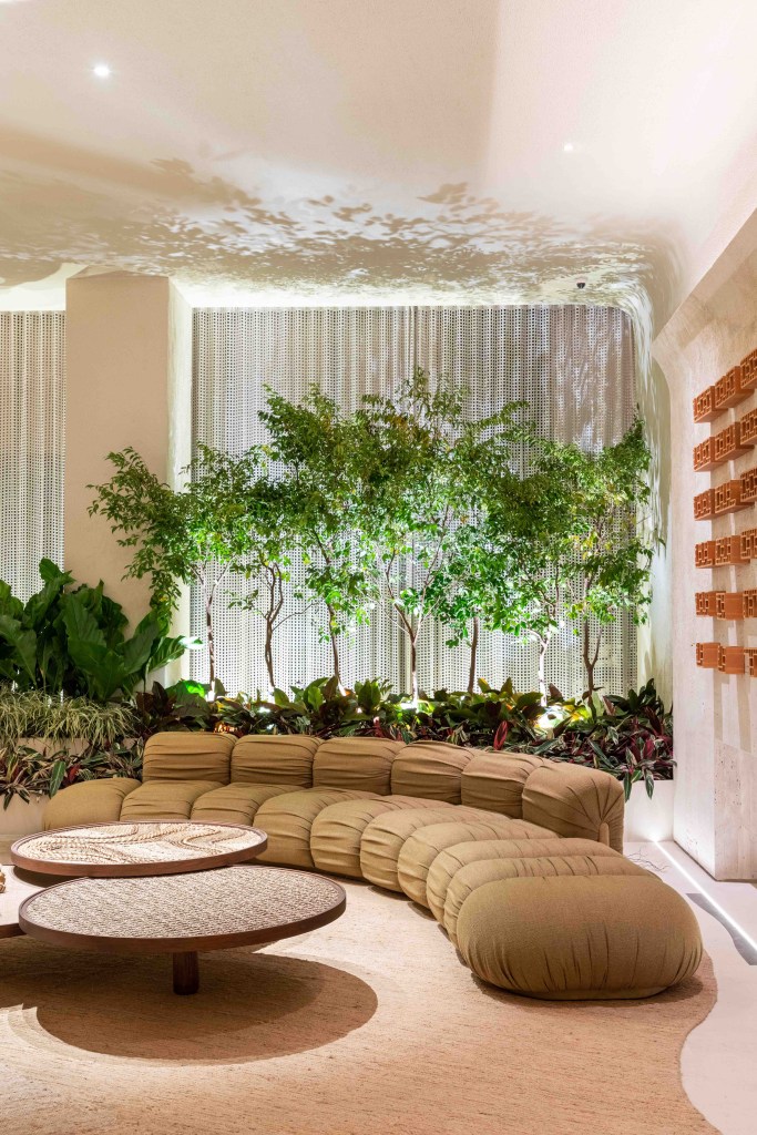 Suite Arquitetos - Casa Kraftizen Cosentino. Projeto da CASACOR São Paulo 2023. Na foto, sala com sofá curvo, jardim e tapete.