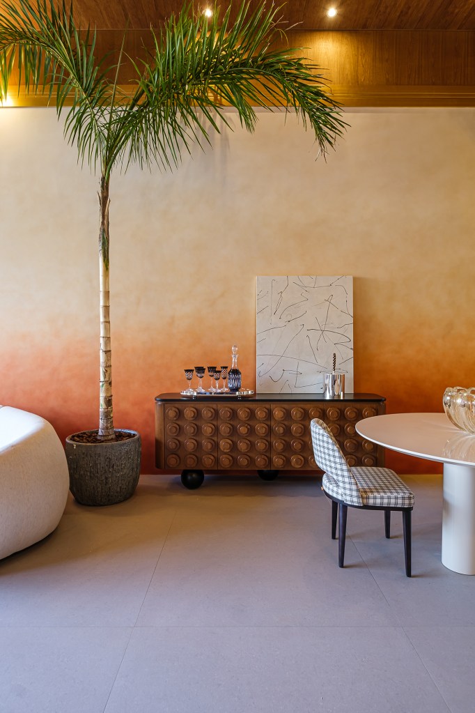 Taynara Wazilewski - Loft Terra Rossa. Projeto da CASACOR Bolívia 2023. Na foto, quarto com parede degradê, árvore e mesa de jantar.