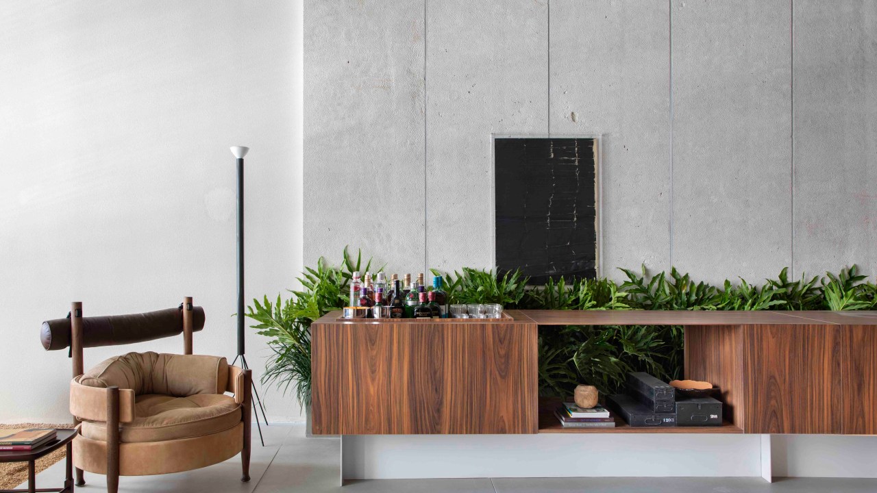 Ticiane Lima - Loft (In)terno. Projeto da CASACOR São Paulo 2023. Na foto, sala com aparador, plantas e poltrona.