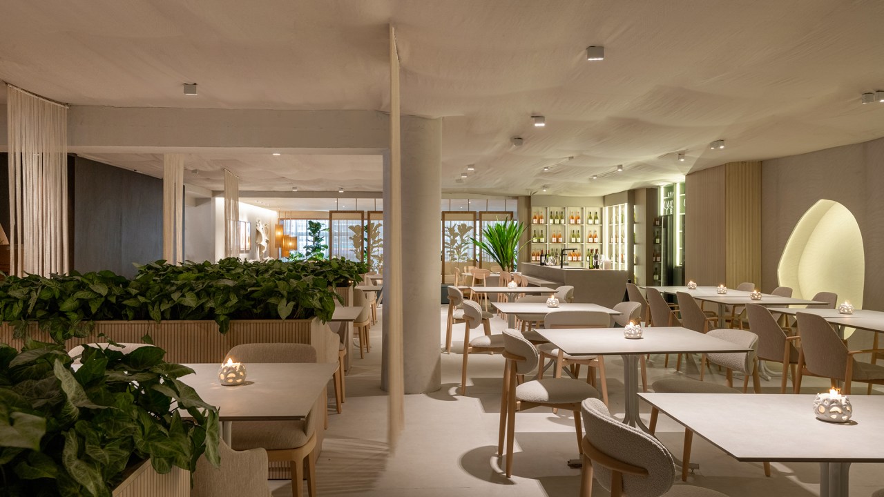 Vilaville Arquitetura - Restaurante Horta. Projeto da CASACOR São Paulo 2023. Na foto, mesas, cadeiras, adega e nichos iluminados.