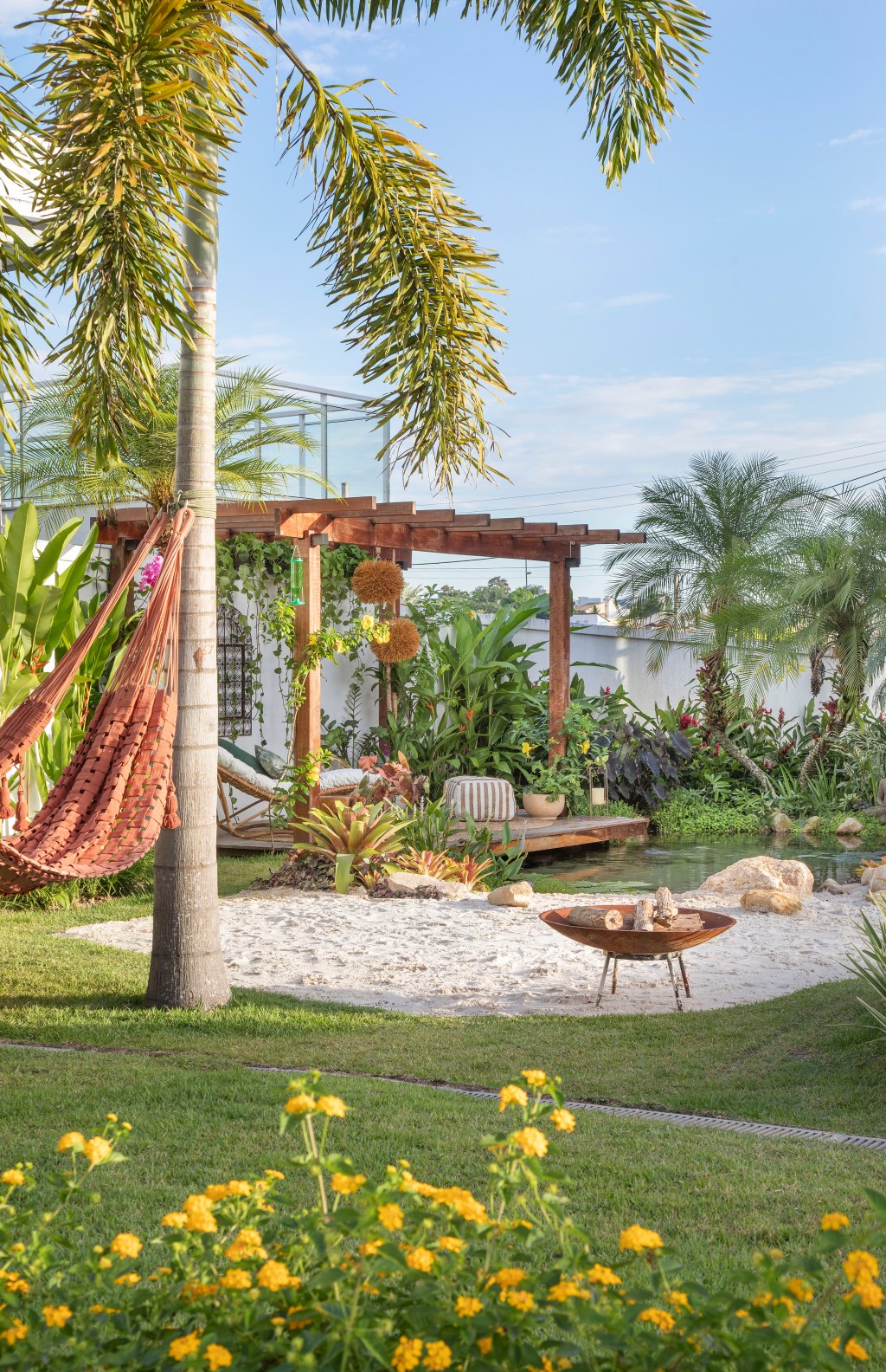 Jardim de 900 m² tem lago com peixes, praia de areia branca e pomar. Projeto de Ana Veras e Bernardo Vieira. Na foto, gazebo com pergolado e prainha com areia.