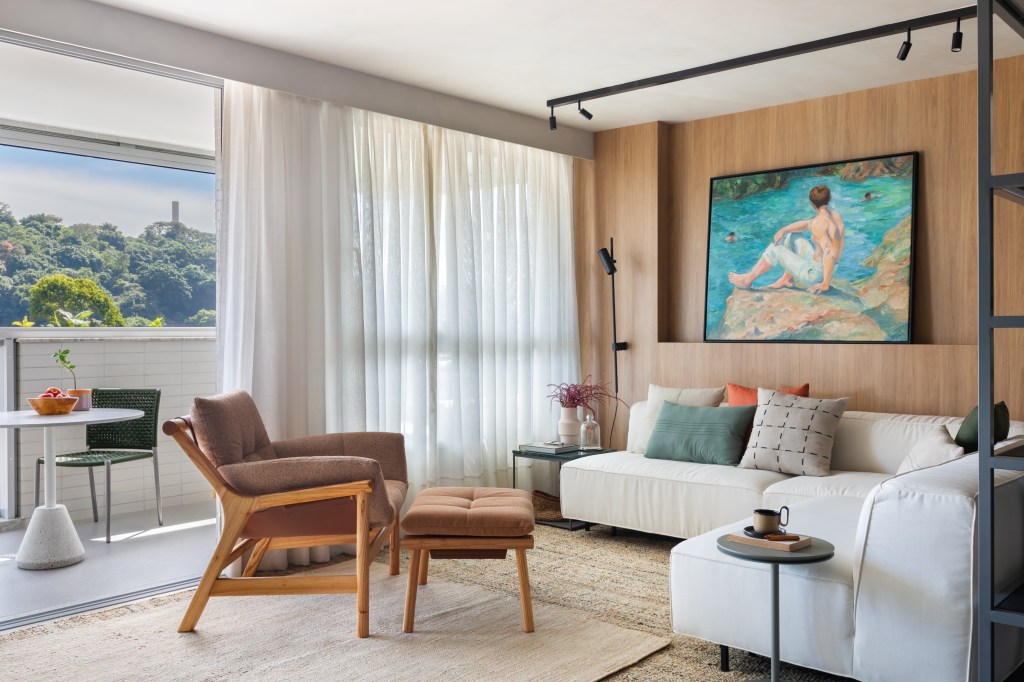 Apê de 82 m² ganha décor japandi com toques contemporâneos. Projeto de Fabiano Ravaglia. Na foto, sala de estar com sofá, nicho para quadro e varanda.