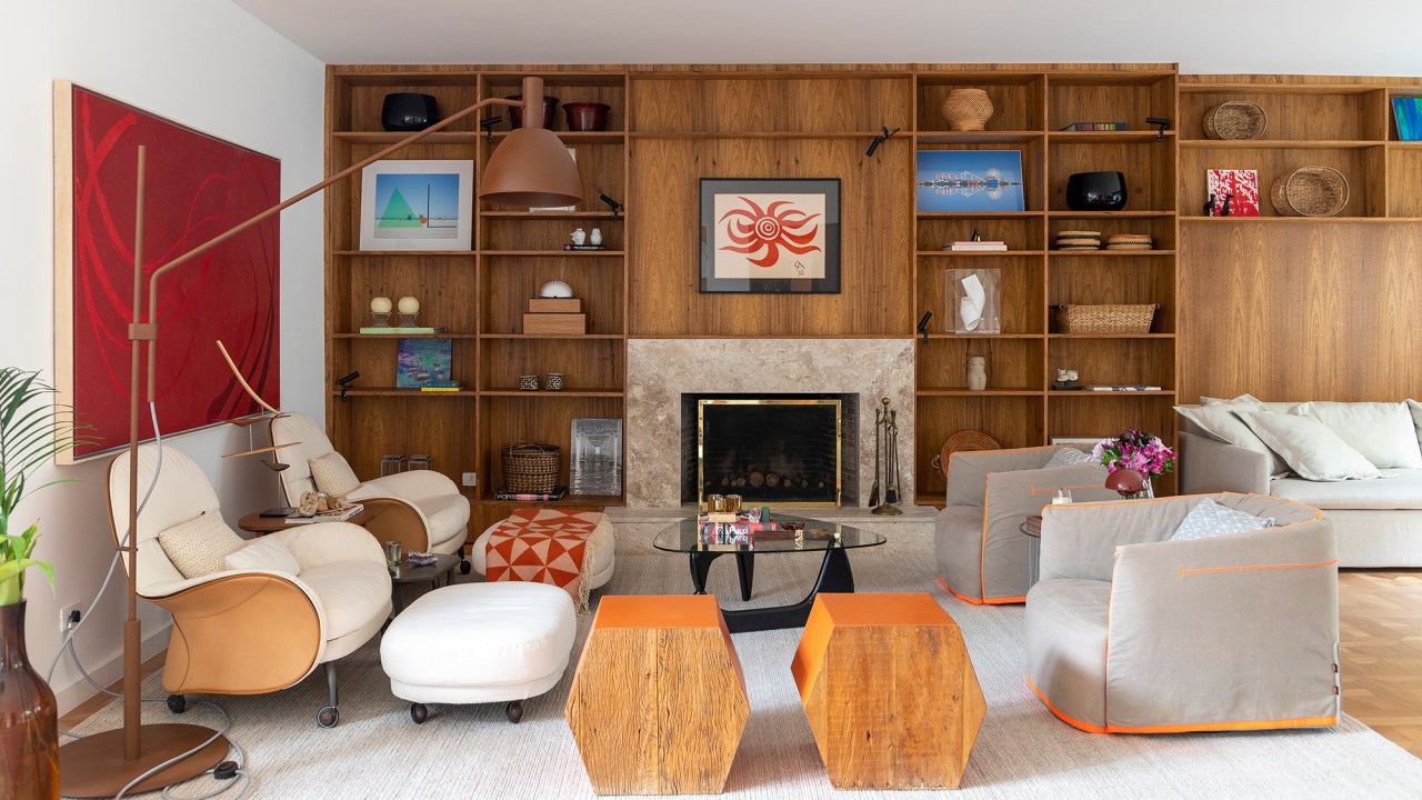 Cacau Ribeiro assina casa charmosa perfeita para a vida em família. Na foto, sala com paineis de madeira e lareira.