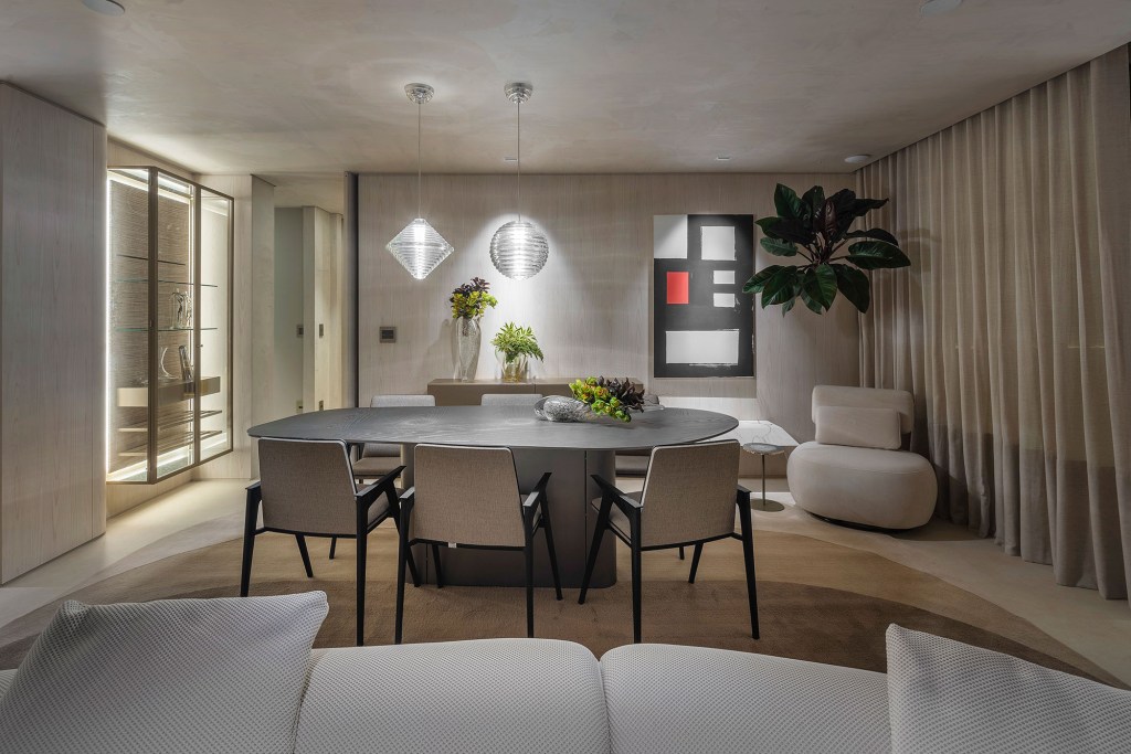 Gislene Lopes - Apartamento Casa Ferolla. Projeto da CASACOR Minas Gerais 2023. Na foto, sala de estar com poltrona, mesa de jantar e tapete.