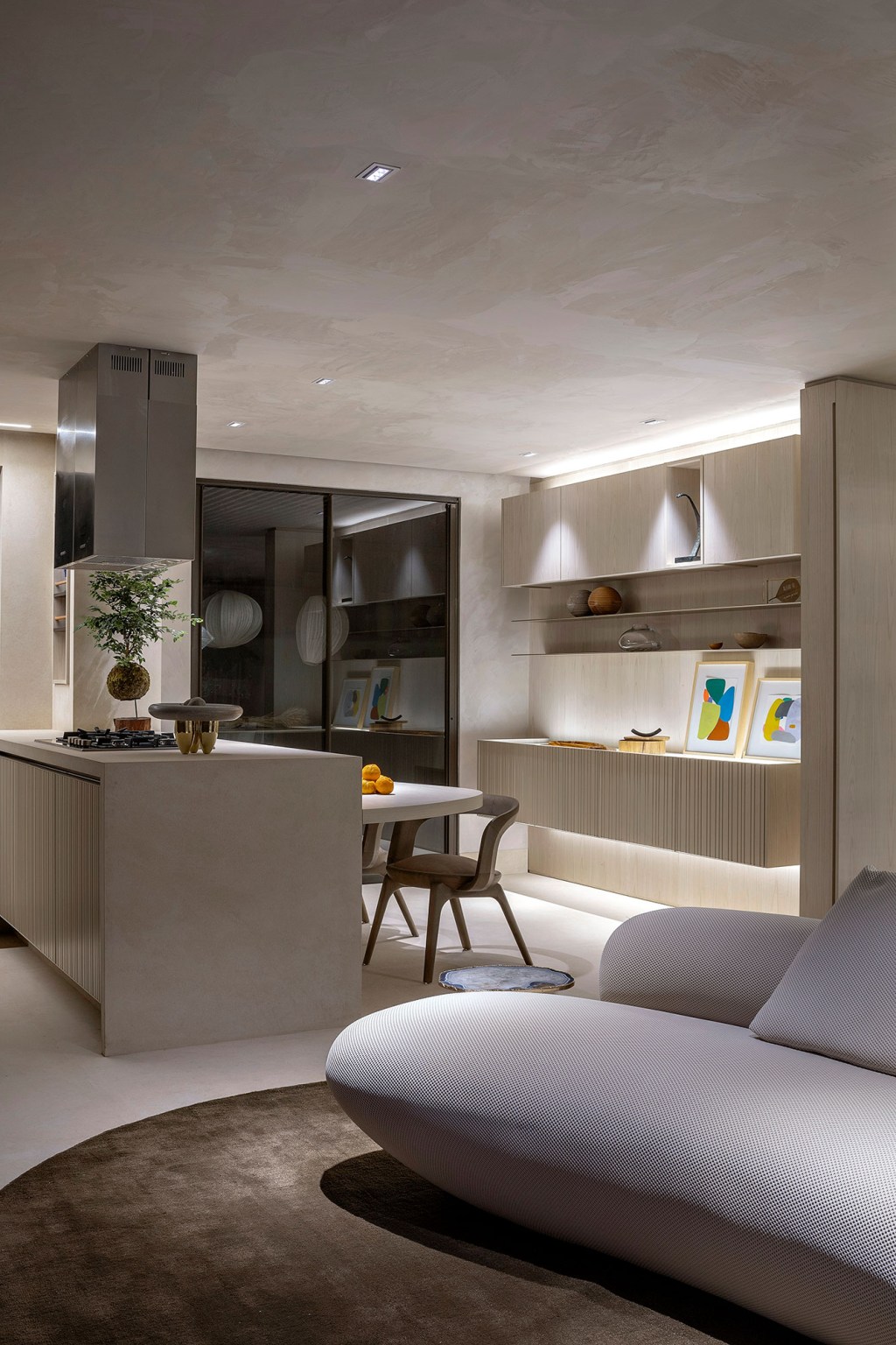 Gislene Lopes - Apartamento Casa Ferolla. Projeto da CASACOR Minas Gerais 2023. Na foto, cozinha integrada com a sala, Bancada e sofá curvo.