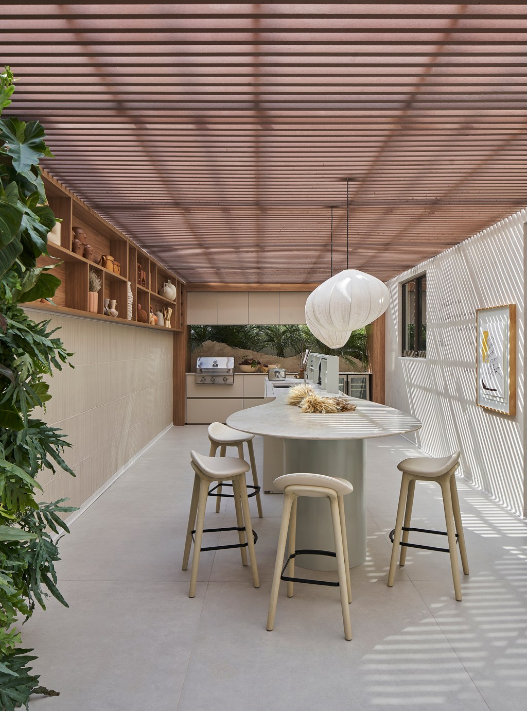 Manuela Senna - Varanda “Sementes Casa Ferolla”. Projeto da CASACOR Minas Gerais 2023. Na foto, varanda com teto ripado, mesa de refeições e plantas.