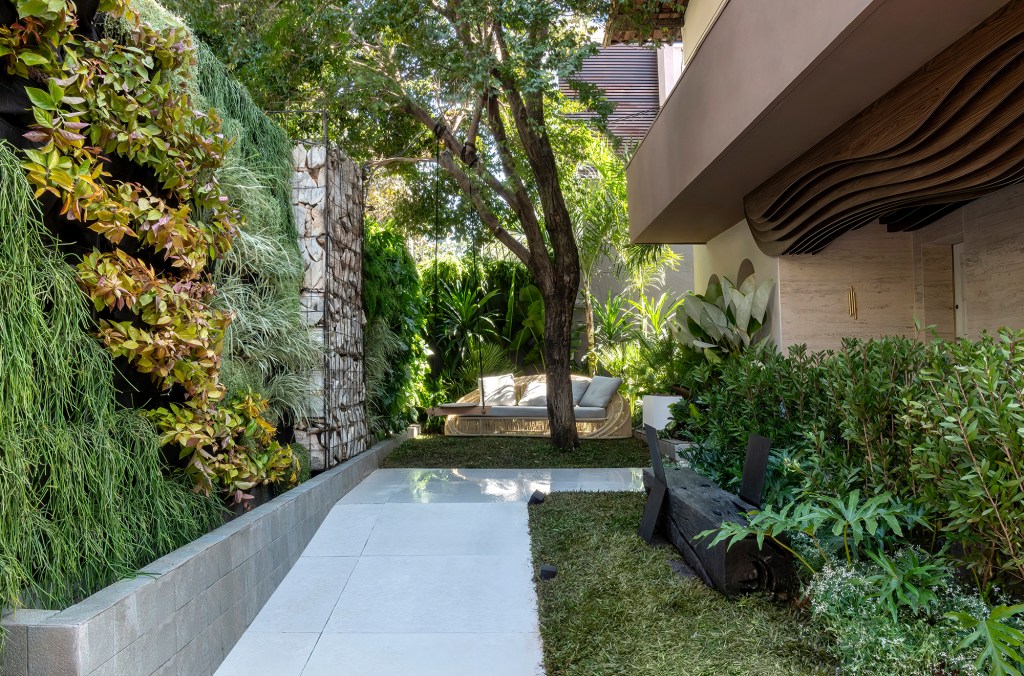 Victor Thauan - Refúgio do Mato. Projeto da CASACOR Minas Gerais 2023. Na foto, jardim com parede verde, banco e muro de pedras.