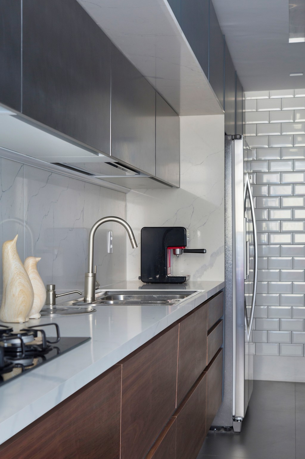 Apê de 95 m² ganha décor masculino para receber amigos e clientes. Projeto de Fabiano Ravaglio. Na foto, cozinha com subway tiles na parede e marcenaria azul.