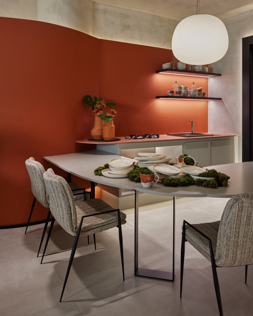 Sala de jantar com mesa e cadeiras e parede laranja