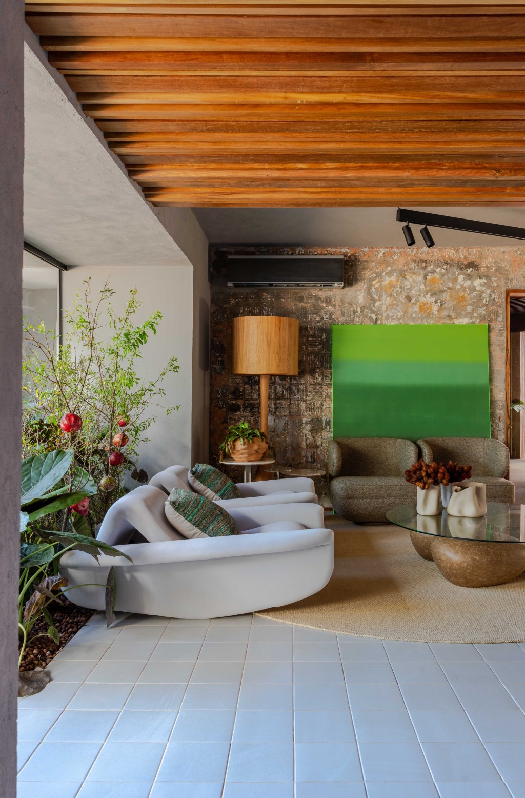 Cozinha Ágape, projeto de Tatiana Melo para a CASACOR Bahia 2023. Na foto, cozinha com sala de estar, jardim e poltronas.