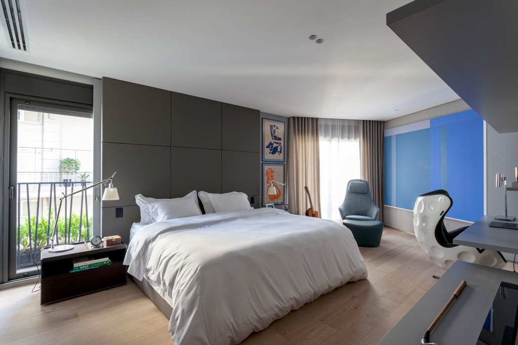 David Bastos assina apê de 268 m² com décor sóbrio e elegante. Na foto, quarto de casal com cama com cabeceira cinza e quadros.
