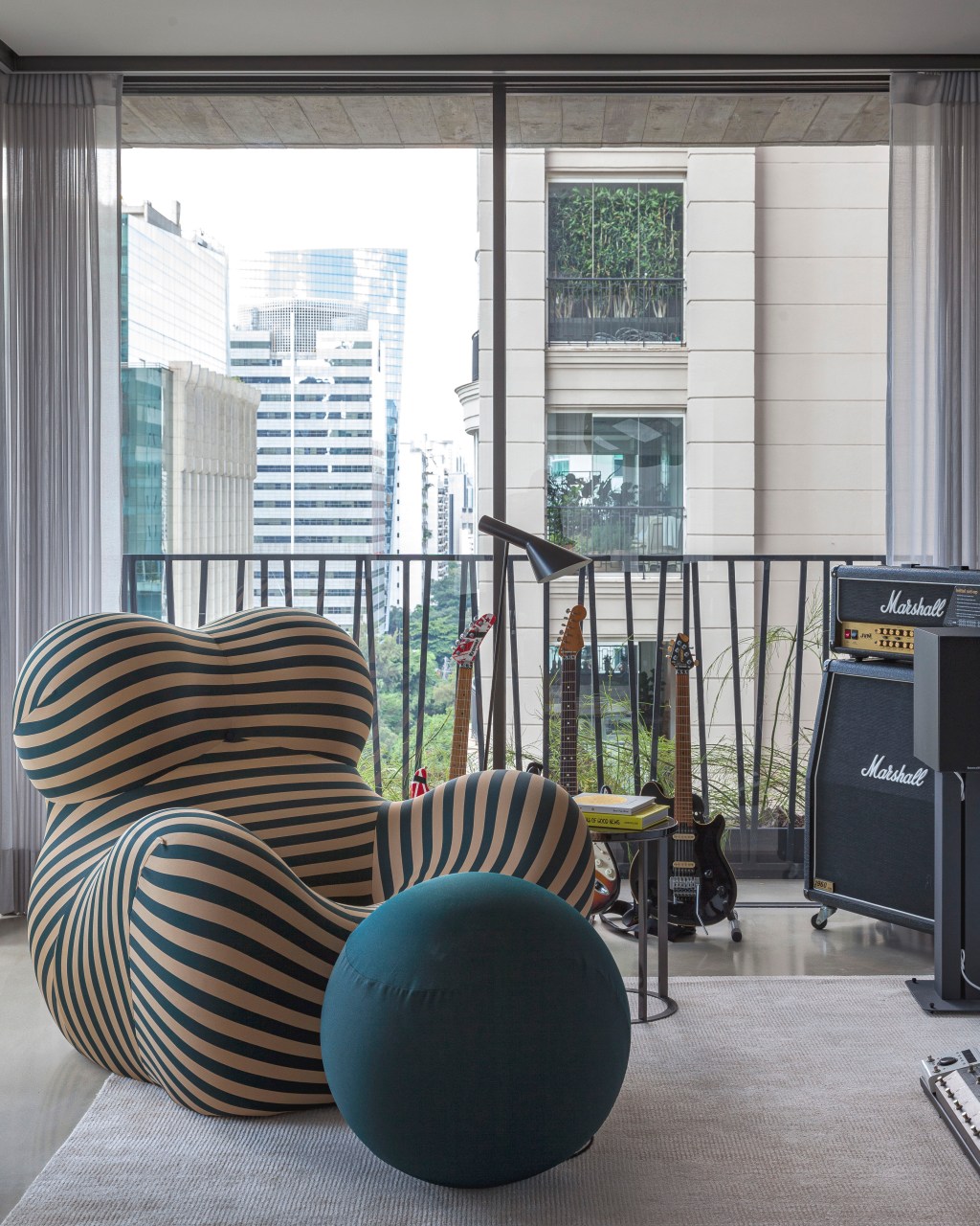 David Bastos assina apê de 268 m² com décor sóbrio e elegante. Na foto, varanda com poltrona Up e guitarras.