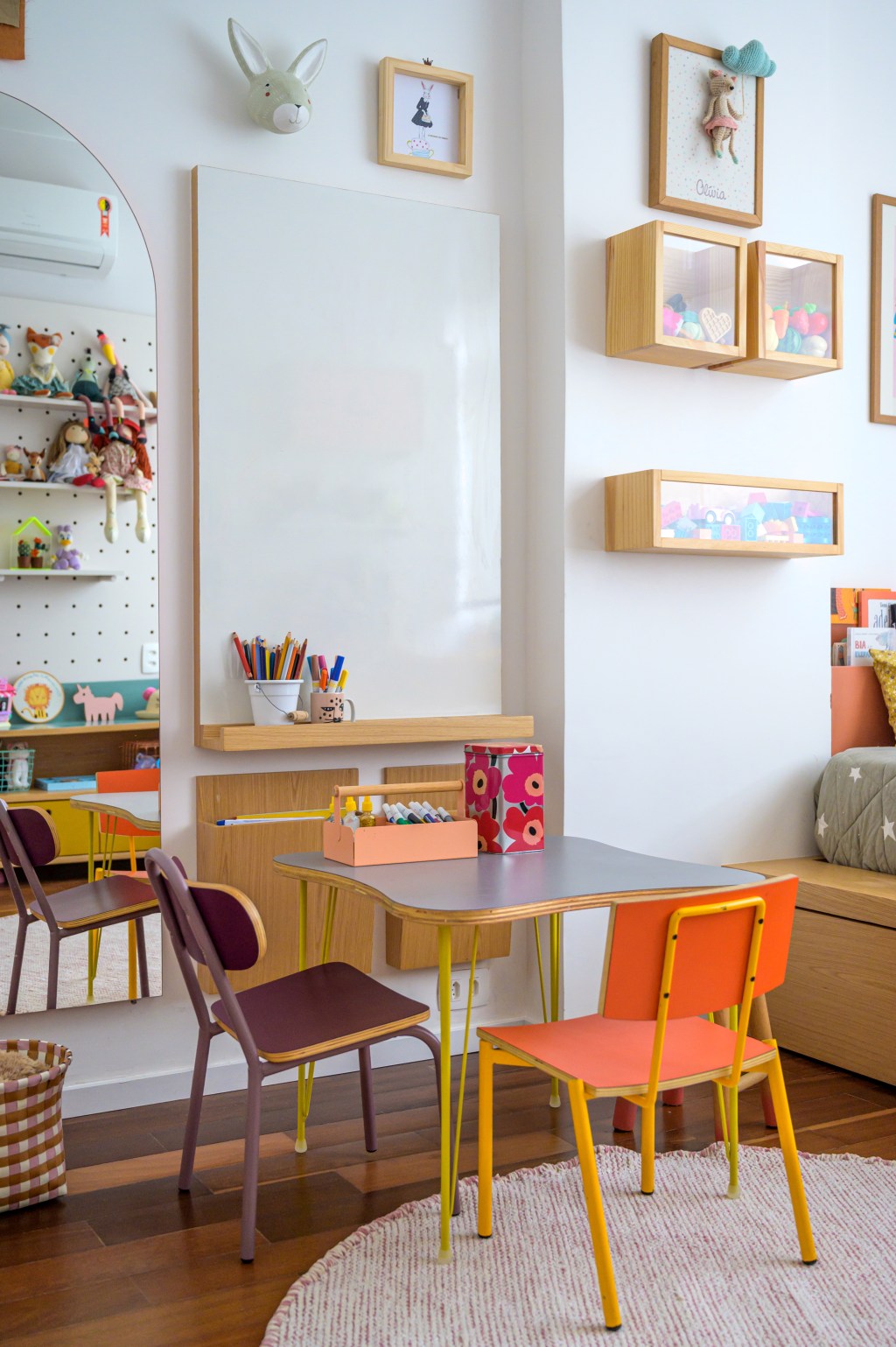 Pilar estrutural e tijolos aparentes dão o tom deste apê de 115 m². Projeto de Ana Neri. Na foto, quarto infantil com mesa, cadeiras e espelho.