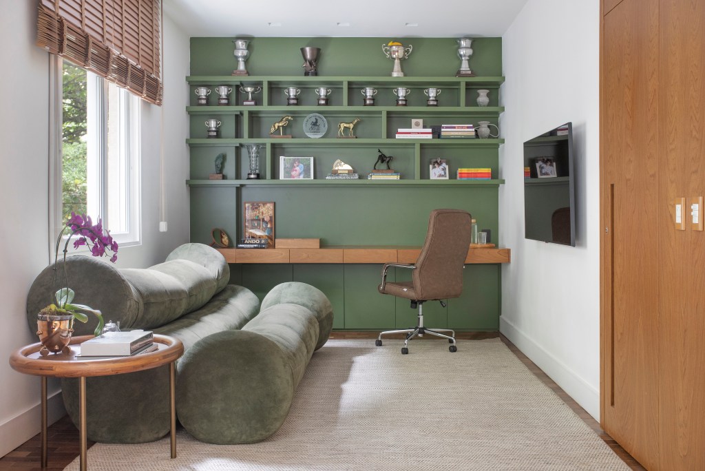 Apartamento em Ipanema é repleto de mobiliário de design brasileiro. Projeto de Bianca Da Hora. Nas foto, home office, com marcenaria verde e sofá verde,