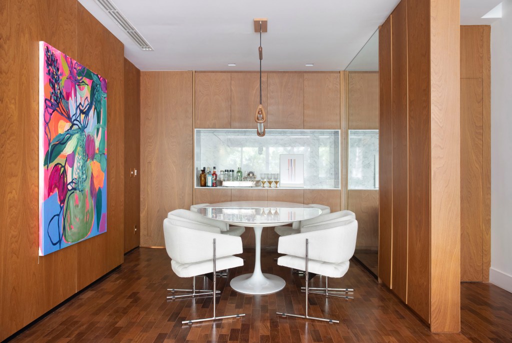 Apartamento em Ipanema é repleto de mobiliário de design brasileiro. Projeto de Bianca Da Hora. Na foto, sala de jantar com bicho bar e quadro.