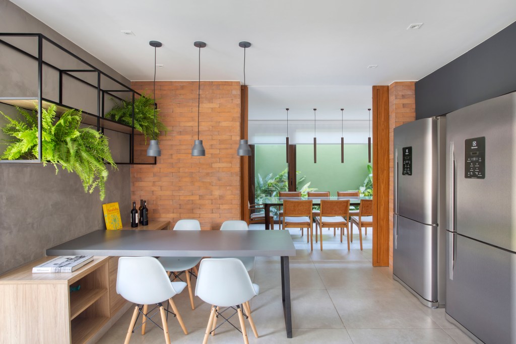 Casa de praia de 420 m² ganha estilo urbano e loft na garagem. Projeto Studio 021 Arquitetura. Na foto, sala de jantar e varanda gourmet.