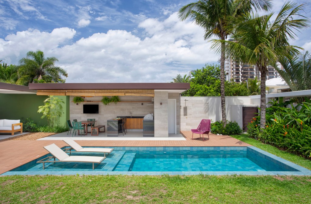Casa de praia de 420 m² ganha estilo urbano e loft na garagem. Projeto Studio 021 Arquitetura. Na foto, varanda gourmet com churrasqueira e piscina.
