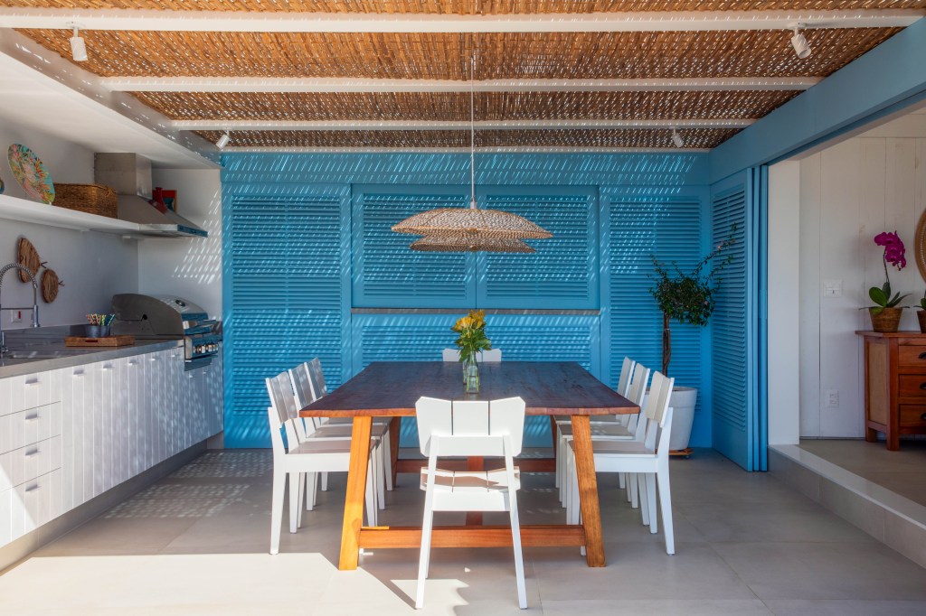 Venezianas azuis na varanda marcam esta casa de praia inspirada na Grécia. Projeto de Brise Arquitetura. Na foto, cozinha provençal com esquadrias azuis.