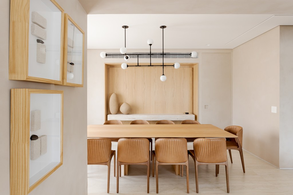 Adega walk-in e muita madeira marcam este apartamento de 300 m². Projeto de Figueiredo Fischer Arquitetos. Na foto, sala de jantar com mesa de madeira e aparador na marcenaria.