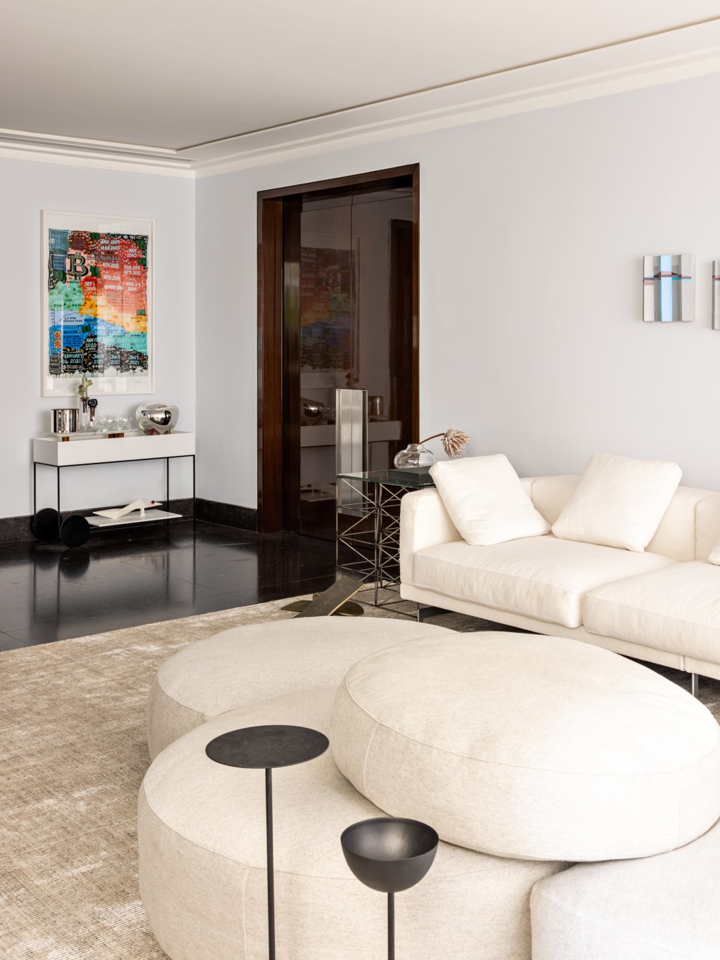 Apartamento de 550 m² ganha espaço para cabine de DJ no living. Projeto de Navarro Arquitetura. Na foto, sala com sofa ilha e quadros.