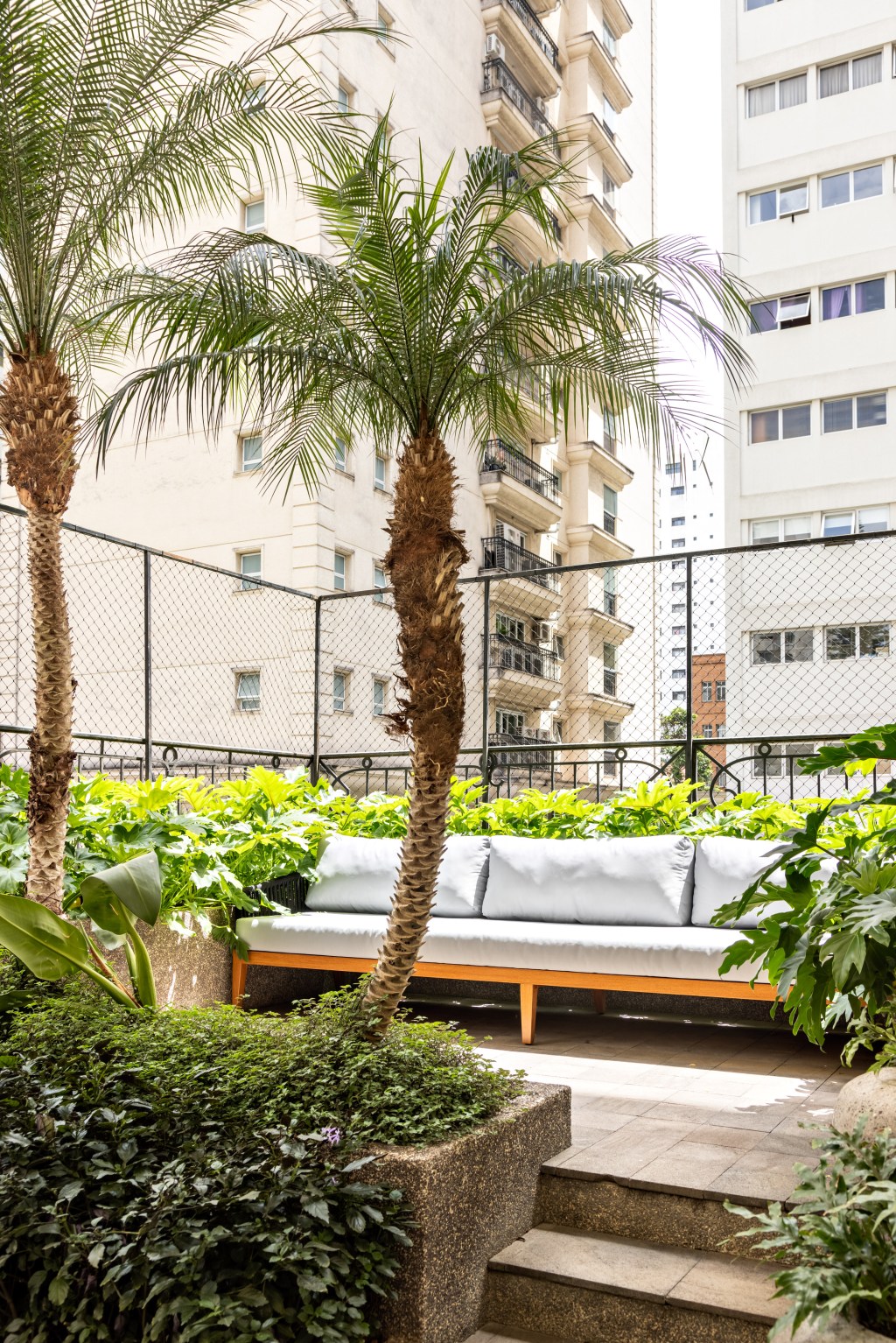 Apartamento de 550 m² ganha espaço para cabine de DJ no living. Projeto de Navarro Arquitetura. Na foto, varanda com banco e plantas.