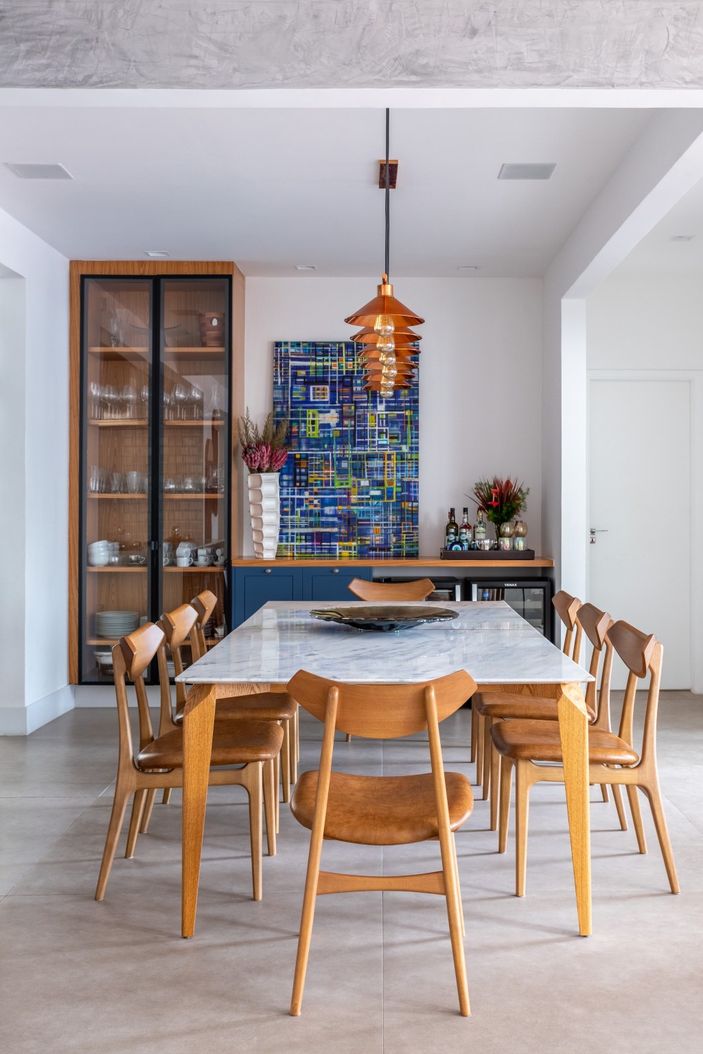 Apê industrial de 200 m² une cores, vidro canelado, tijolos e sofá jeans. Projeto de Ana Cano. Na foto, sala de jantar com cristaleira e marcenaria azul.