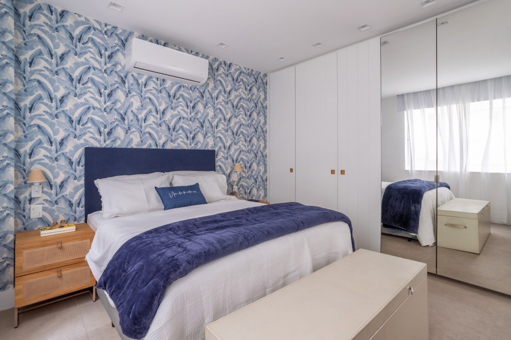Apê industrial de 200 m² une cores, vidro canelado, tijolos e sofá jeans. Projeto de Ana Cano. Na foto, quarto de casal com papel de parede azul.