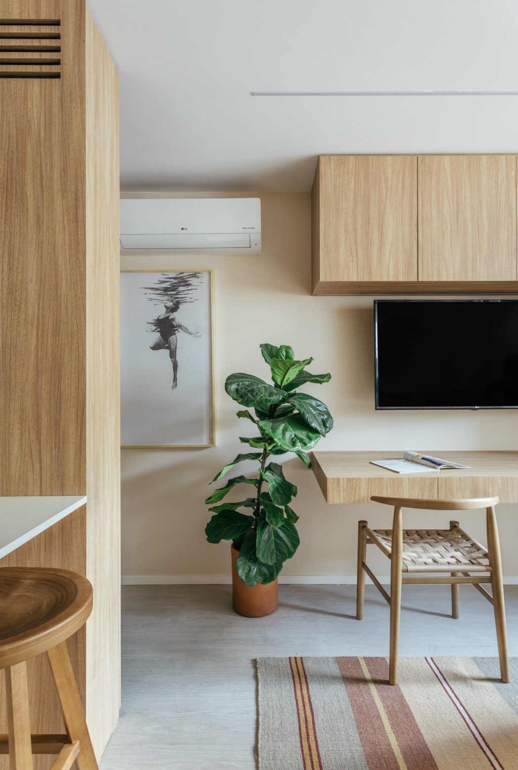 Micro apê de 25 m² tem cabeceira de azulejos e cozinha integrada ao quarto. Projeto de Rodolfo Consoli. Na foto, quarto com Tv e home office.