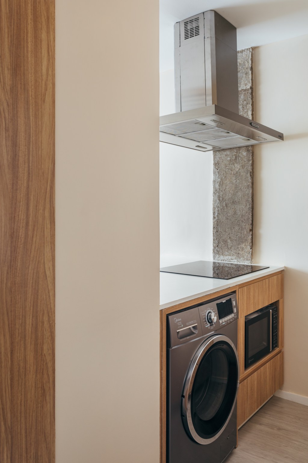 Micro apê de 25 m² tem cabeceira de azulejos e cozinha integrada ao quarto. Projeto de Rodolfo Consoli. Na foto, lavanderia integrada com a cozinha.