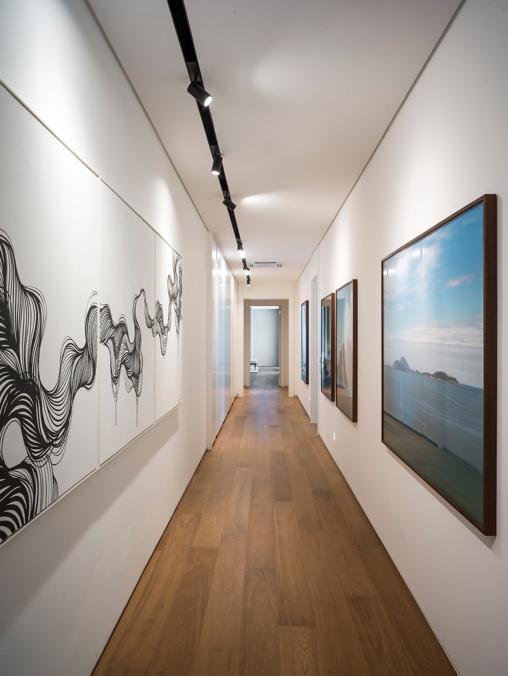 Paola Ribeiro assina apartamento de 810 m² repleto de arte. Na foto, corredor com quadros.