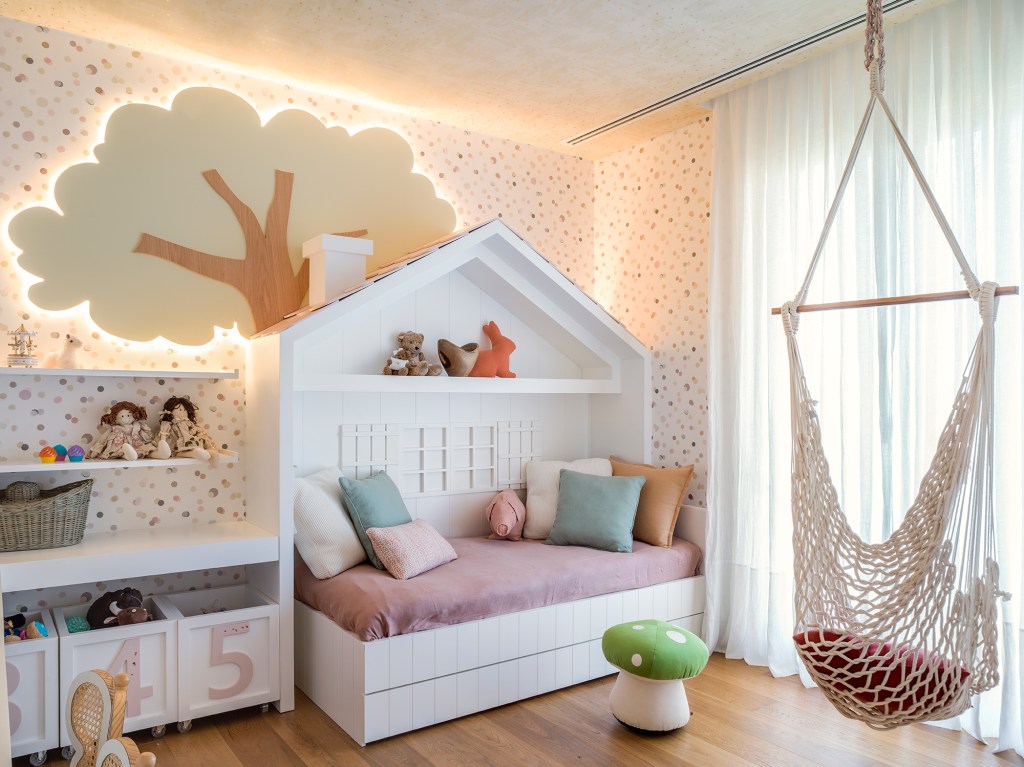Paola Ribeiro assina apartamento de 810 m² repleto de arte. Na foto, quarto infantil com árvore iluminada e cama em formato de casinha.