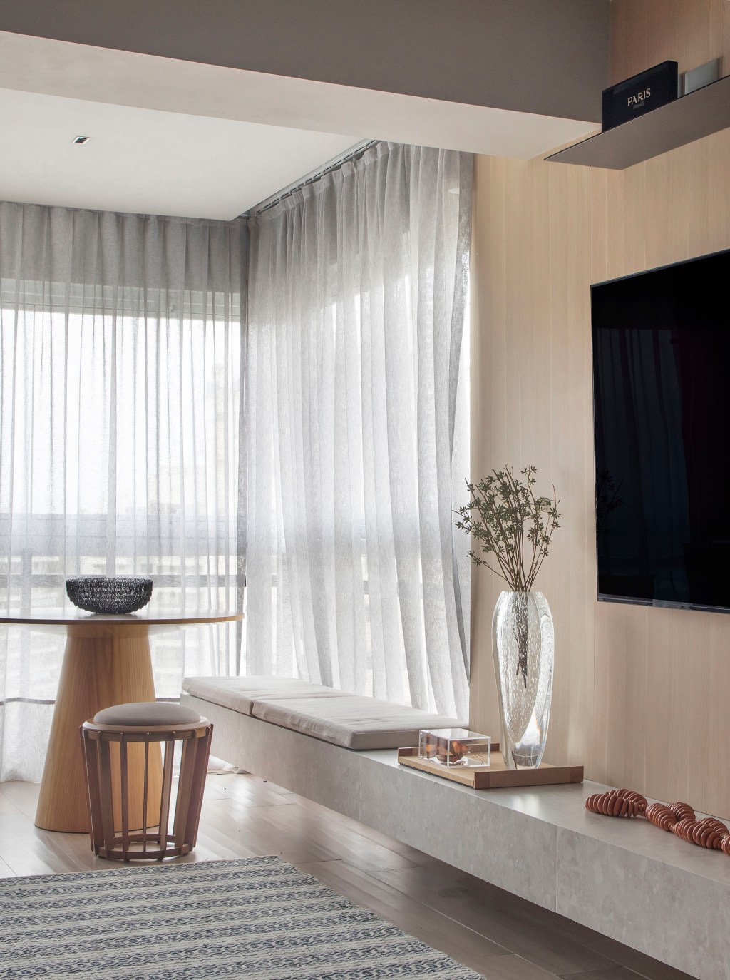 Preto e terracota marcam o décor deste apartamento masculino de 110 m². Projeto de Up3 Arquitetura. Na foto, sala com painel de TV de madeira e cortina de linho.