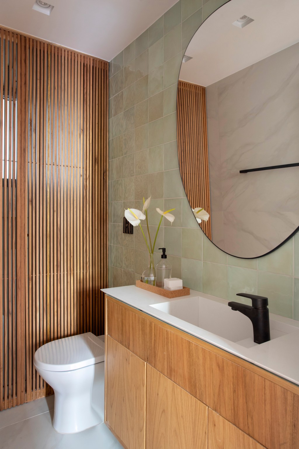 Apartamento de 110 m² ganha décor aconchegante com clima carioca. Projeto de Rafael Ramos. Na foto, lavabo com parede ripada.
