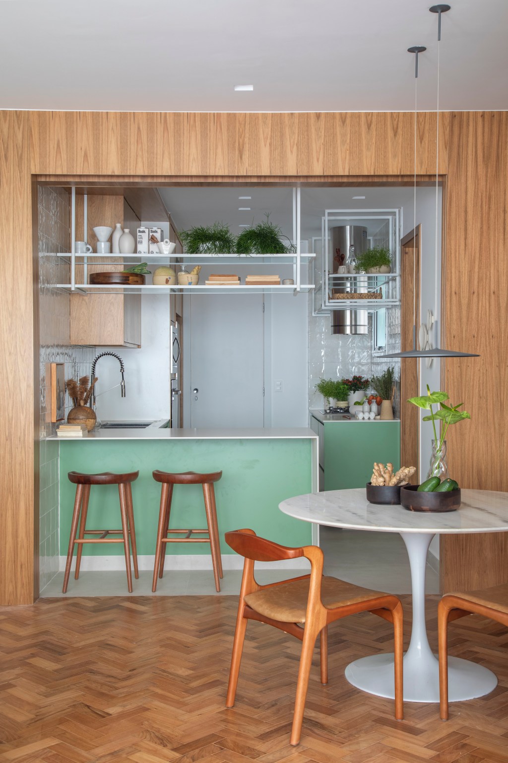 Apartamento de 110 m² ganha décor aconchegante com clima carioca. Projeto de Rafael Ramos. Na foto, cozinha com prateleira suspensa e marcenaria verde.