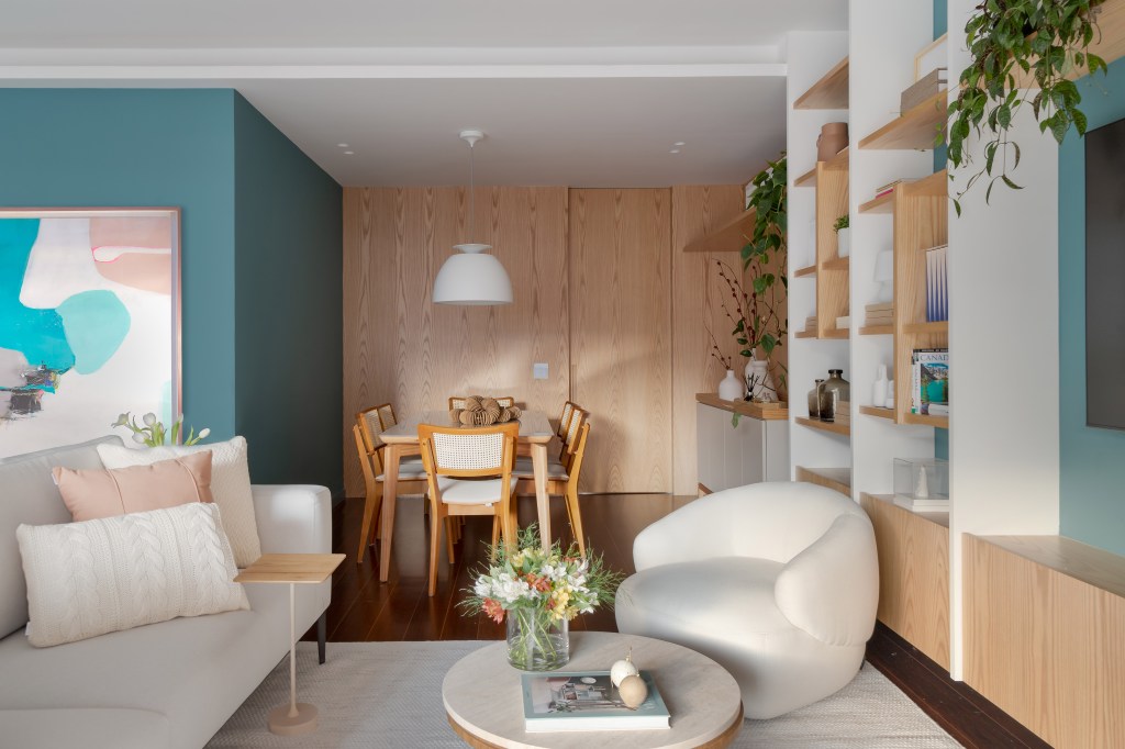 Apartamento de 140 m² ganha charme com paredes azuis e verdes. Projeto de Maia Romeiro Arquitetura. Na foto, sala de jantar com parede verde e piso de madeira.