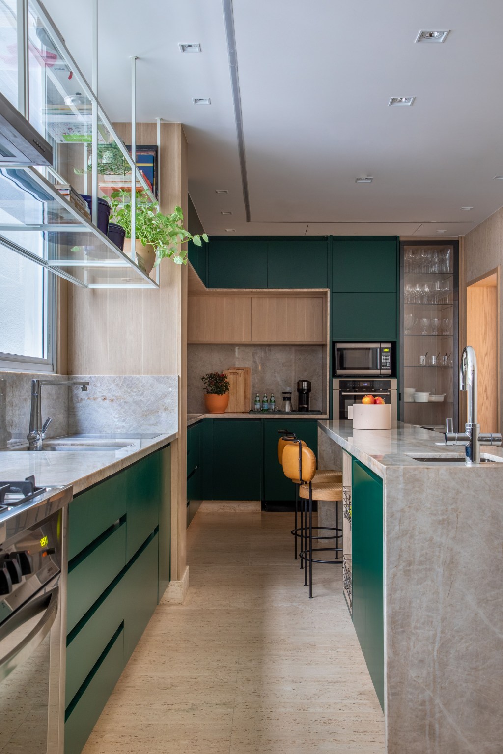 Apartamento com vista para praia ganha espaço de coworking na sala. Projeto de Up3 Arquitetura. Na foto, cozinh com marcenaria verde.