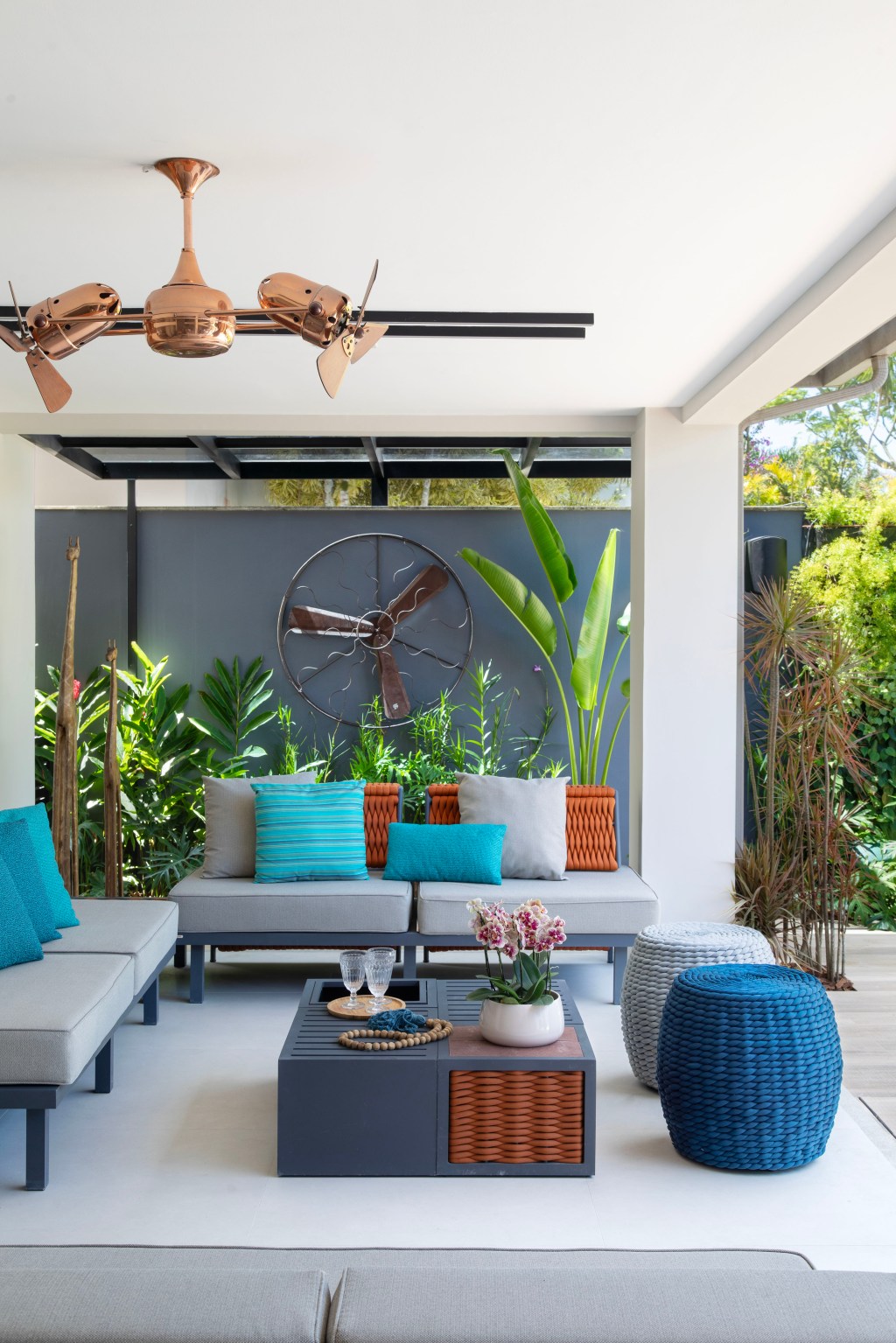 Área de 360 m² ganha jardim com paisagismo tropical e muitas flores. Projeto Maira Duarte. Na foto, varanda com sofá e plantas.