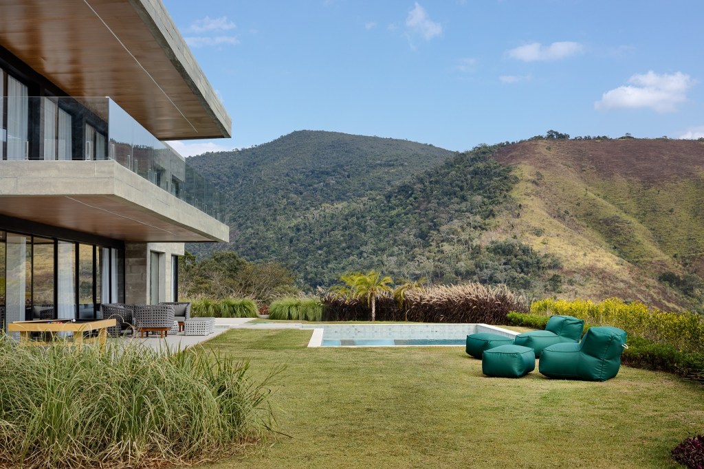 Casa de 1200 m² na serra tem clima de clube de férias. Projeto de Rafael Mirza. Na foto, Na foto, piscina com vista para a montanha.