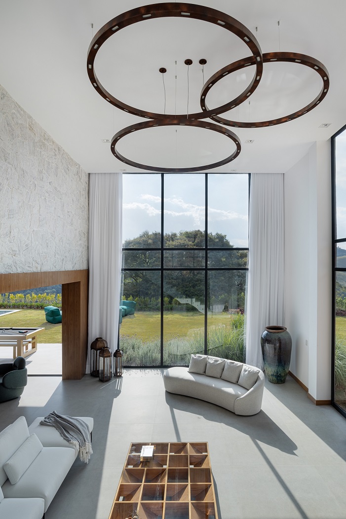 Casa de 1200 m² na serra tem clima de clube de férias. Projeto de Rafael Mirza. Na foto, Na foto, sala de estar com pé-direito duplo.