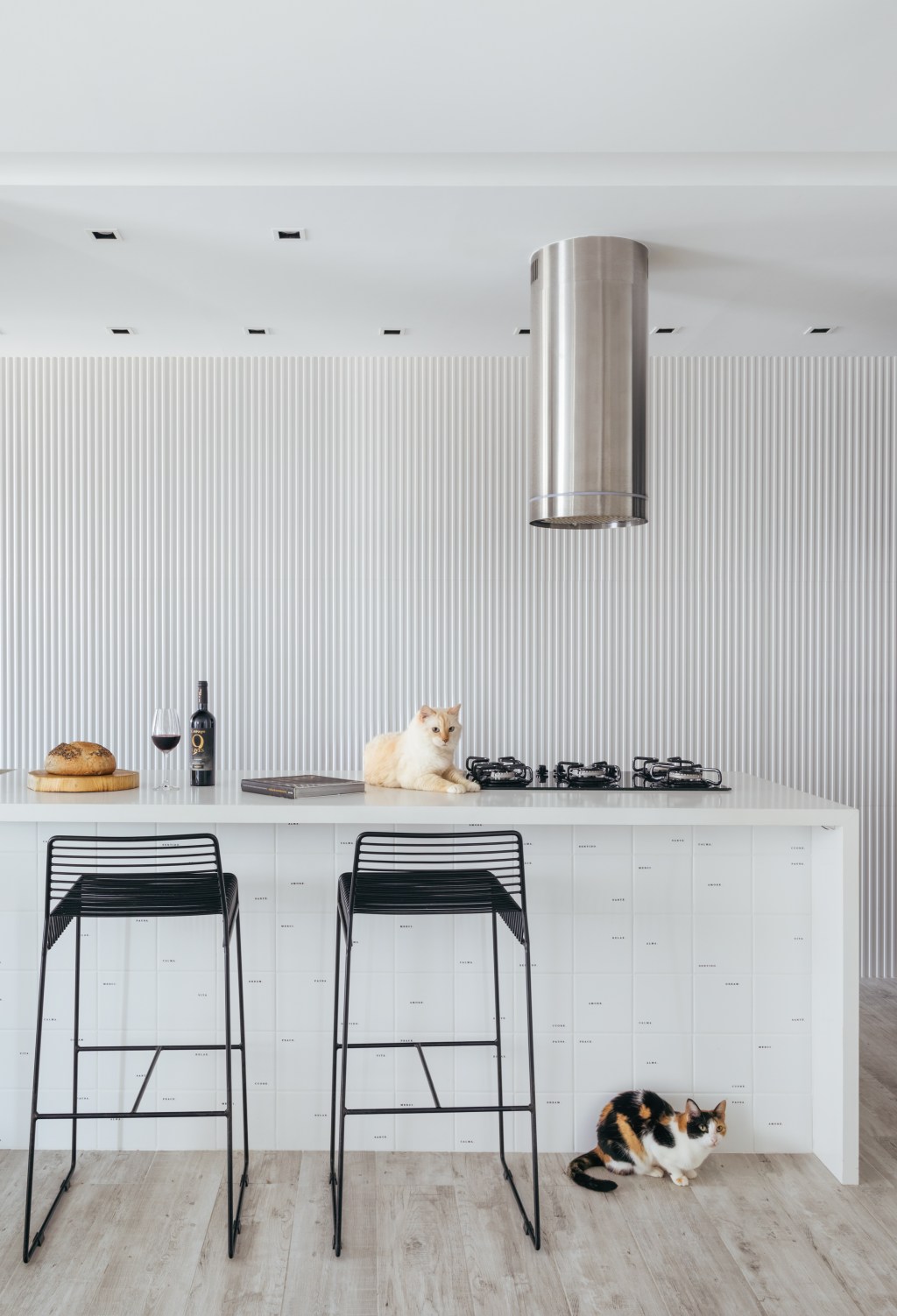 Apê de 84 m² em estilo escandinavo foi pensado para os gatos da moradora. Projeto de Nilton Montarroyos. Na foto. cozinha com balcão branco e parede ripada.